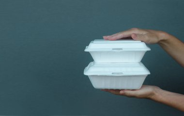 Kadının elleri paket köpük beslenme çantalarını tutuyor. Tek kullanımlık yiyecek kapları, kapatın..