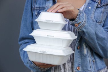 Kadının elleri paket köpük beslenme çantalarını tutuyor. Tek kullanımlık yiyecek kapları, kapatın..