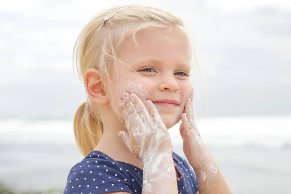 Carino Bambina Che Applica Crema Protettiva Sulla Spiaggia Lozione Solare — Foto Stock