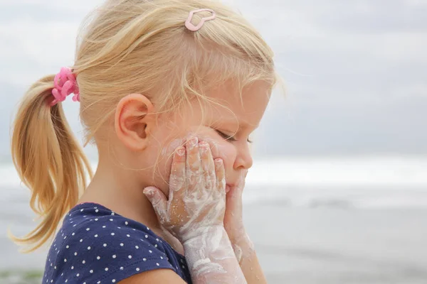 Carino Bambina Che Applica Crema Protettiva Sulla Spiaggia Lozione Solare — Foto Stock