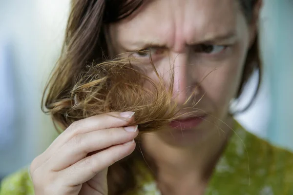 Žena Dívá Její Suché Spletené Vlasy Končí — Stock fotografie