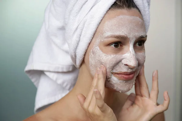浴室里的年轻女人裹着带面罩的毛巾 家庭温泉和皮肤护理概念 — 图库照片