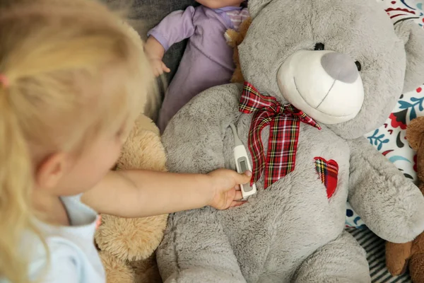 Adorável Menina Criança Loira Brincando Com Termômetro Cuidando Seu Ursinho — Fotografia de Stock