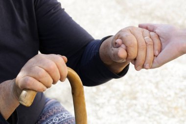 El ele tutuşmak. Genç ve yaşlı ellerin bir resmi. Umut, ilgi, sevgi ve destek kavramı.