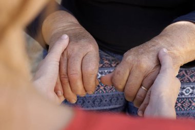 El ele tutuşmak. Genç ve yaşlı ellerin bir resmi. Umut, ilgi, sevgi ve destek kavramı.