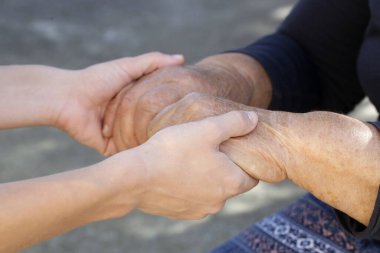 El ele tutuşmak. Genç ve yaşlı ellerin bir resmi. Umut, ilgi, sevgi ve destek kavramı.