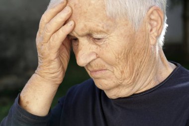Son sınıf beyaz kadın elini alnına dayadı. Baş ağrısı, depresyon veya Alzheimer hastalığı belirtileri.