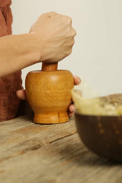 Woman preparing natural medicines with mortar and pestle. Process of making natural cosmetic or herbal infused oil.