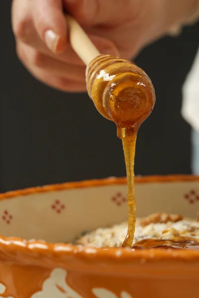 蜂蜜从木棍上滴下 厨房里的女人用的是木制蜂蜜搅拌器 — 图库照片