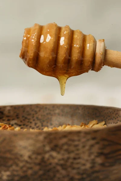 蜂蜜从木棍上滴下 厨房里的女人用的是木制蜂蜜搅拌器 — 图库照片