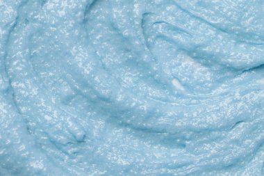 Mavi doğal kozmetik yüz maskesi deoksifikasyonu, desenli arka plan. Mavi killi yüz maskesi, kapat.