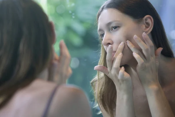 Retrato Uma Bela Jovem Mulher Banheiro Examinando Seu Rosto Espelho — Fotografia de Stock