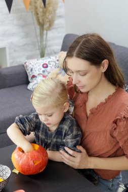 Sevimli küçük kız annesiyle Cadılar Bayramı süslemeleri hazırlıyor. Autumn DiY teknesi evde. 