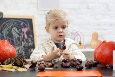 Cadılar Bayramı süslemeleriyle oynayan tatlı küçük kız. Autumn DiY teknesi evde. 