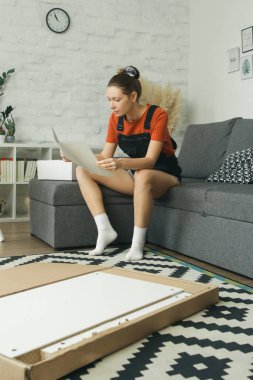 Kafkas kadın evde tek başına mobilya montajı yapıyor.