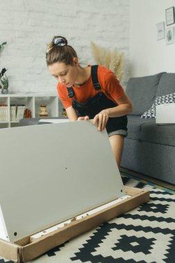 Kafkas kadın evde tek başına mobilya montajı yapıyor.