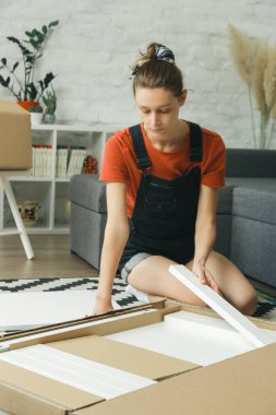 Kafkas kadın evde tek başına mobilya montajı yapıyor.