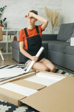 Kafkas kadın evde tek başına mobilya montajı yapıyor.