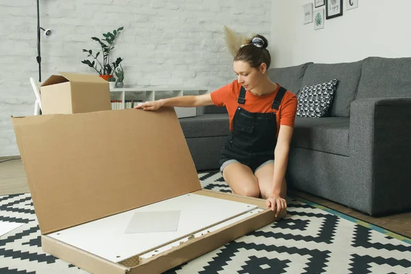 Caucasian woman at home assembling furniture by herself