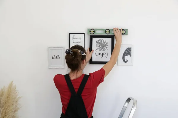 Kobieta Aranżowanie Ramki Obraz Ścianie Nowym Domu Diy Koncepcji Poprawy — Zdjęcie stockowe