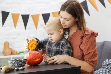 Sevimli küçük kız annesiyle Cadılar Bayramı süslemeleri hazırlıyor. Autumn DiY teknesi evde.