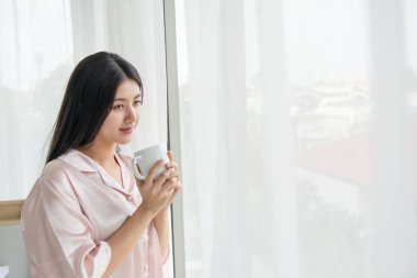 Yan görünüm portre güzel bir kadın bir cof tutarak görünümlü düşünme