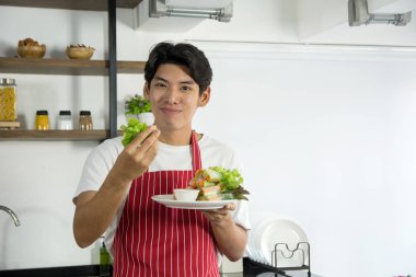 Sağlıklı menü sunan kırmızı önlük genç iyi görünümlü adam 