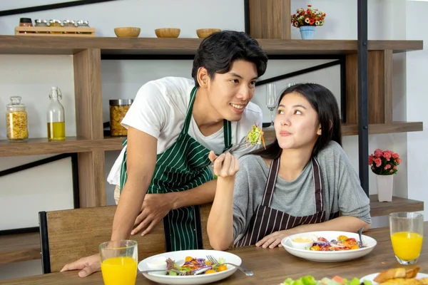 Cute happy couple having breakfast having salad in modern kitche — Stock Photo, Image