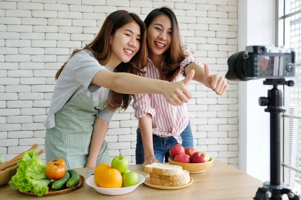 Vide kayıt sırasında konuşan iki genç asya kadın gıda blogcular
