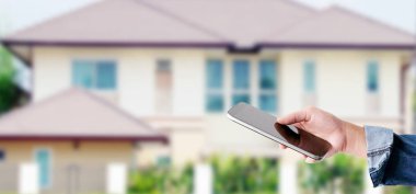 Bulanık ev arka plan, afiş, akıllı üzerinde akıllı telefon kullanarak el
