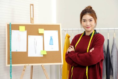 Genç asyalı kadın moda tasarımcısı happin ile stüdyoda çalışıyor