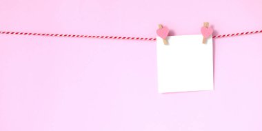 Boş beyaz kağıt not defteri pembe arka plan üzerinde asılı, kopya ile 