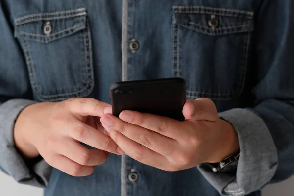 Mano del hombre usando el teléfono inteligente negro, la gente en el teléfono, la tecnología y — Foto de Stock