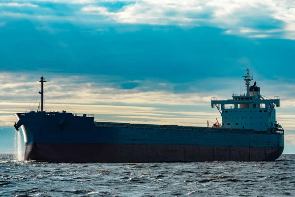 Merchandise import. Large blue cargo ship moving to Riga port