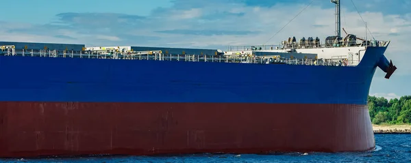 Merchandise import. Large blue cargo ship moving to Riga port