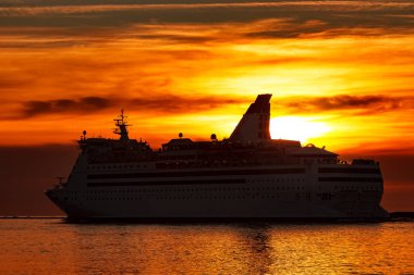 Turuncu günbatımı gökyüzü karşı hareketli beyaz yolcu gemisi