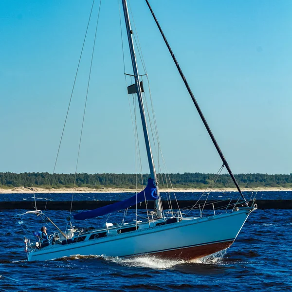 Small sailboat jumping on the waves at summer
