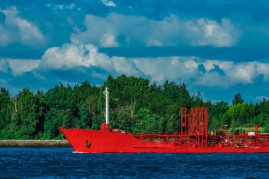 Nehir kenarında hareketli kırmızı kargo tanker gemisi