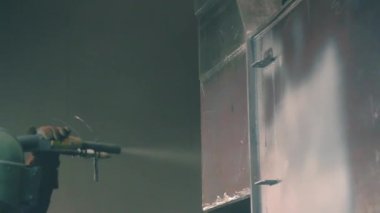 Adam metal yüzey Kumlama cihazının silah bir metal konstrüksiyon fabrikada tarafından temizler. Shotblaster bir süreç içinde