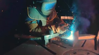 Profesyonel yarı otomatik kaynak kiti 380 volt ve ilâ 300 amper süper ağır çekimde. Kaynakçı koruma maskesi ile metal konstrüksiyon fabrikada çalışıyor. Ağır sanayi atölye