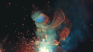 Profesyonel yarı otomatik kaynak kiti 380 volt ve ilâ 300 amper süper ağır çekimde. Kaynakçı koruma maskesi ile metal konstrüksiyon fabrikada çalışıyor. Ağır sanayi atölye