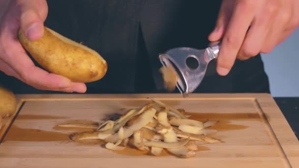 Man is Peeling Potato in a Kitchen — Stock Video