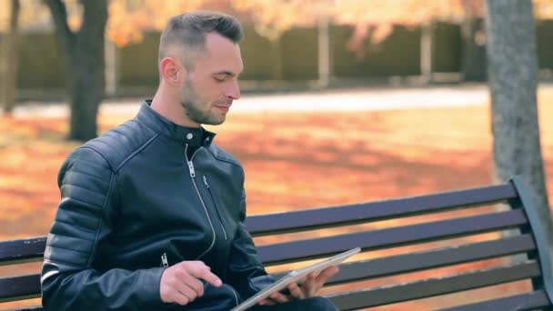 Man in a Park Χρησιμοποιώντας Big White Tablet PC — Αρχείο Βίντεο