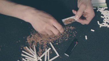 El yapımı sigarayı yuvarlayan adam.