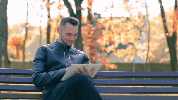 Man in a Park Χρησιμοποιώντας Big White Tablet PC — Αρχείο Βίντεο
