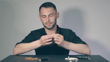 El yapımı sigarayı yuvarlayan adam.