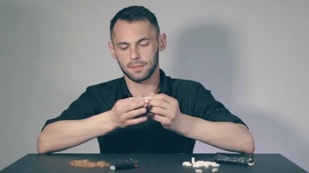 Muž válí ručně vyrobenou cigaretu — Stock video