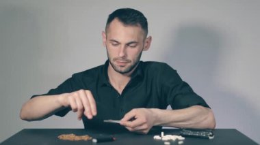 El yapımı sigarayı yuvarlayan adam.