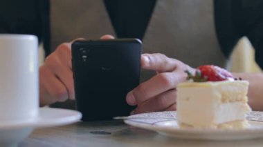 Kahve molası sırasında akıllı telefon kullanan bir müşteri.