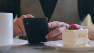 Kahve molası sırasında akıllı telefon kullanan bir müşteri.